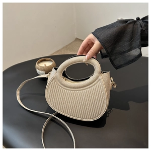Detailed texture of the woven beige half-moon bag with elegant pleated design and top handle