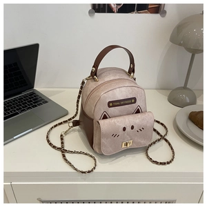 Close-up of mini beige backpack featuring cat ear details and a metal chain strap