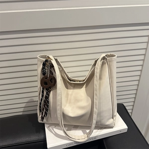 Retro cremefarbene große Wildleder Eimertasche mit dekorativem braunem Anhänger