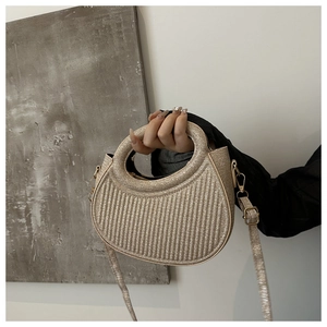Detail of champagne gold crescent bag with vertical embossing and hollow circular handle
