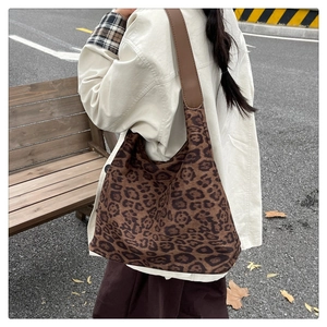 Detail der modischen Hobo-Tasche mit Leopardenmuster und braunem breitem Schultergurt
