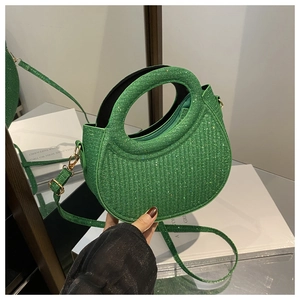 Detail of green sequin handbag with round handle and adjustable shoulder strap