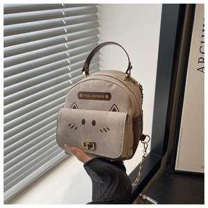 Detailed view of mini grey canvas backpack with leather handle and cute cartoon design