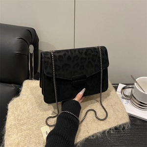 Sac bandoulière élégant à imprimé léopard avec chaîne en métal et rabat sur canapé