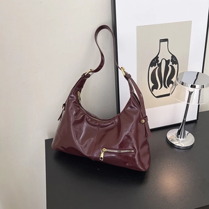 Fashionable burgundy hobo shoulder bag with glossy finish and gold zipper accents