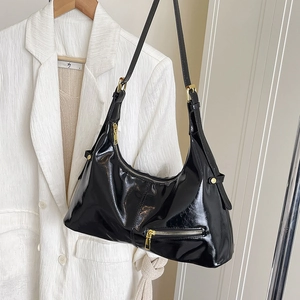 Fashionable black patent leather hobo bag with gold hardware and adjustable strap