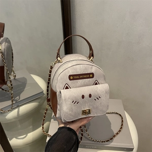 Mini cat-themed gray and brown backpack with chain strap on a mirror background