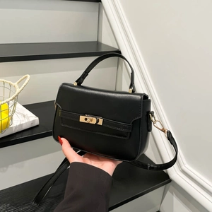 Classic black leather satchel bag with golden buckle hardware and top handle strap