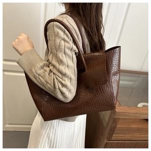 Brown crocodile texture tote bag styled with casual outfit for an elegant look