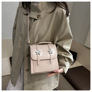 Détail du sac bandoulière en similicuir rose pâle avec boucles d'étoiles argentées