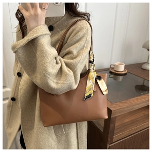 Caramel brown leather tote bag detail with decorative vintage silk scarf on shoulder