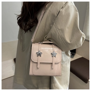 Détail d'un sac à dos en cuir PU crème avec boucles étoiles argentées et fini brillant