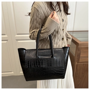 Model showing a black crocodile embossed leather tote bag with side wings for daily commute