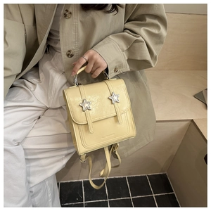 Détail d'un mini sac à dos en cuir verni jaune crème avec des étoiles argentées