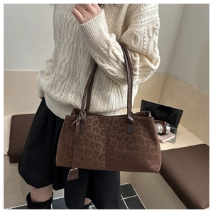 Détail du sac à bandoulière léopard porté avec une tenue décontractée en intérieur chic