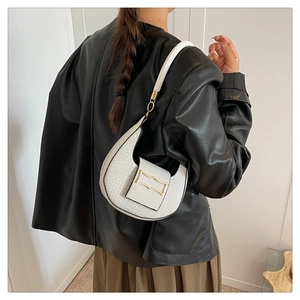 Detail of stone pattern PU leather on a minimalist cream white half-moon shoulder bag
