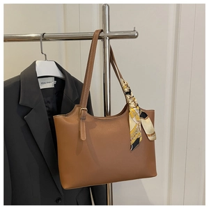 Brown leather tote with contrast stitching and decorative silk scarf detail