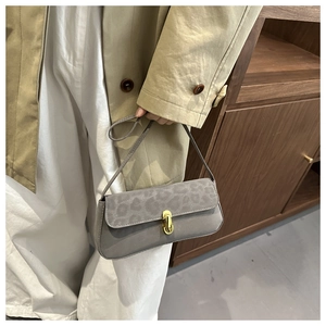 Detail of leopard print suede flap and golden metal clasp on gray crossbody bag