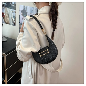 Detailed view of black crocodile pattern faux leather half-moon shoulder bag with gold buckle