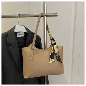 Detail of khaki tote bag with textured faux leather and geometric silk scarf accessory