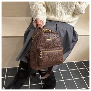 Detail of dark brown woven PU leather mini backpack with polished gold hardware zippers