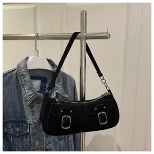 Detail of black canvas shoulder bag featuring dual front pockets and silver pin buckles