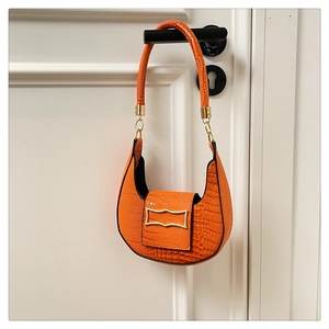 Macro detail of vibrant orange crocodile texture PU leather shoulder bag with gold hardware