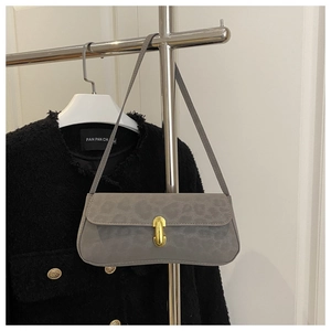 Detail of grey leopard embossed underarm bag with a vintage gold metal buckle closure