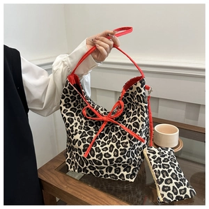 Detail view of leopard print tote bag with red bow and matching pouch set