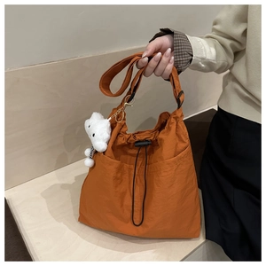 Details der karamellfarbenen Nylon-Einkaufstasche mit Kordelzug und weißem Teddybären