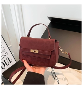 Close-up of burgundy leopard print handbag featuring a gold square twist lock closure