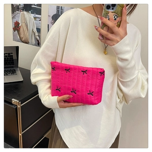 Primer plano de bolsa cosmética rosa acolchada con lazos negros y nailon brillante
