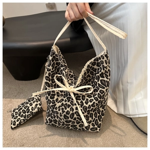Detailed shot of leopard print canvas bucket bag with bow accents and matching pouch