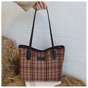 Détail de la texture à carreaux du sac en laine avec étiquette Fashion & Bags et sangle