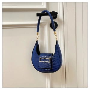 Detailed view of crocodile pattern blue half-moon bag with elegant golden hardware