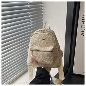 Macro view of cream woven PU leather backpack texture and golden zipper detailing