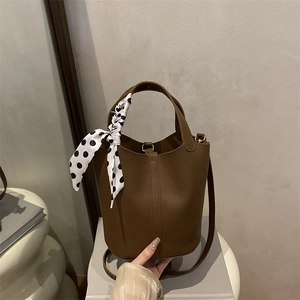 Brown litchi grain leather bucket bag with silk scarf detail and adjustable shoulder strap