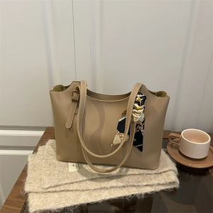 Classic beige tote bag with a patterned silk scarf and slim shoulder straps for daily commute