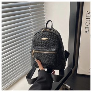 Detailed view of black woven PU leather mini backpack with polished gold hardware zippers