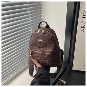 Close-up of dark brown woven backpack texture with premium gold zipper details