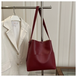 Close-up of vintage burgundy leather bucket bag with fine grain and stitched pocket