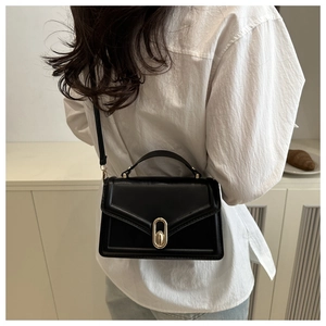 Detailansicht der schwarzen PU-Lederhandtasche mit goldenem Oval-Drehverschluss für Damen