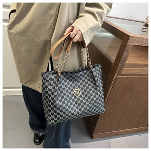 Détail du sac cabas avec motif jacquard blanc et logo métallique doré en forme de M