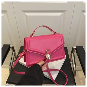 Detail der fuchsiafarbenen Ledertasche mit edler Goldschnalle und elegantem Tragegriff
