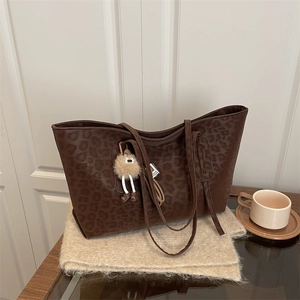 Chic leopard print large tote bag for women with fluffy charm on cozy scarf background