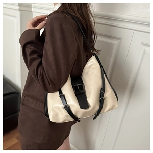 Detail of minimalist cream tote bag with black strap and large metal buckle detail