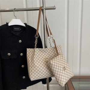 Ensemble sac cabas beige avec imprimé monogramme et logo doré suspendu au cintre
