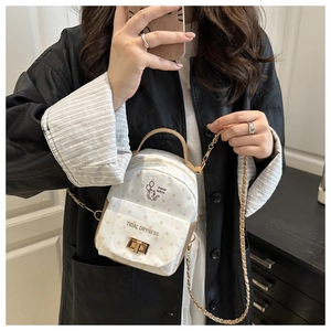 Detailed close-up of a white polka dot mini backpack featuring cute cat print and gold chain