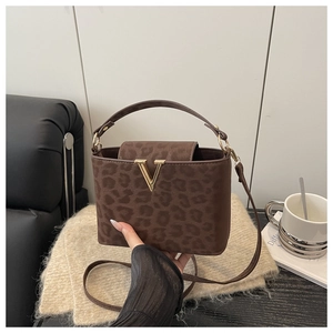 Close-up of leopard print handbag with golden V-logo and adjustable shoulder strap