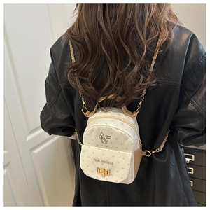 Close-up of polka dot canvas mini backpack with cat illustration and metal chain strap
